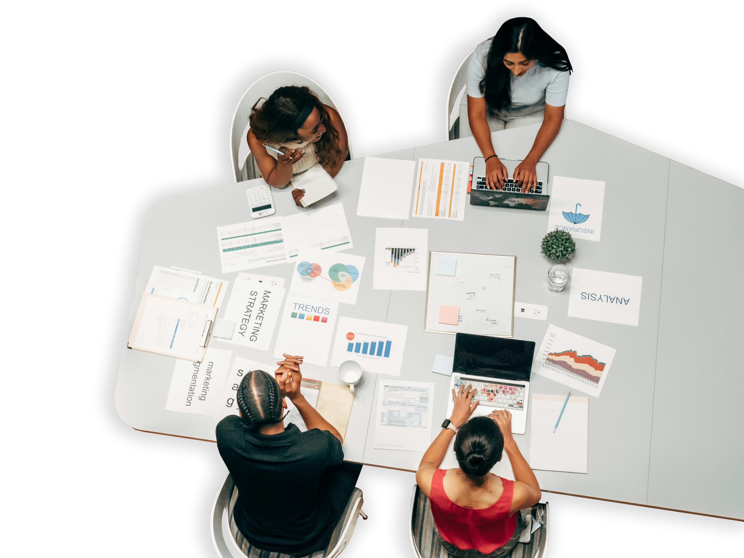 Mesa triangular com pessoas sentadas em volta discutindo. Folhas e pranchetas de marketing ao centro da mesa.